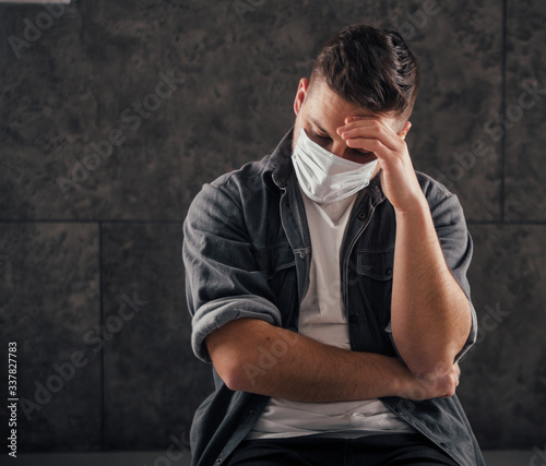 Young man with black mask in dark room pray for world and coronavirus quarantine