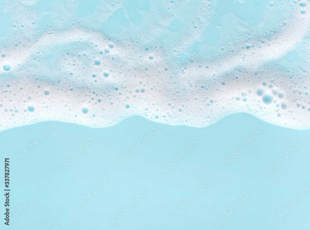 border of soap foam on turquoise background, with copy space