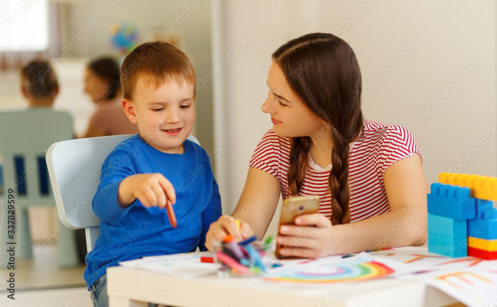 Mother with the baby son with colored pencils and laugh Mother with the baby son with colored pencils and laugh