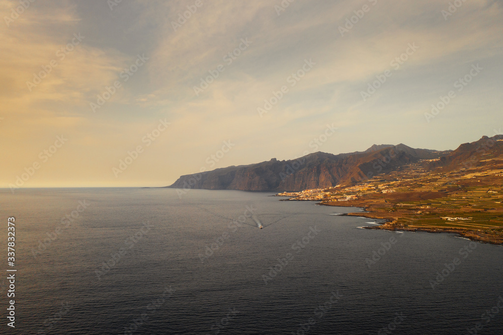 view of the coast of the island of Tenerife, a ship sailing in the distance
