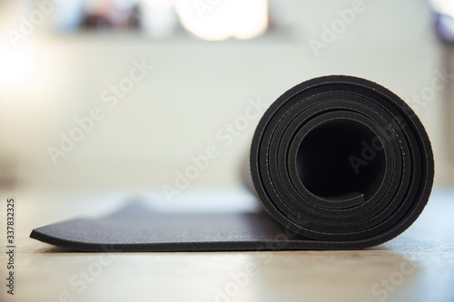 a yoga mat folded into a roll lies on the floor