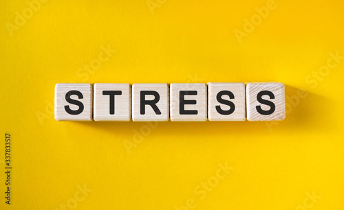 Stress - text on wooden cubes and yellow background