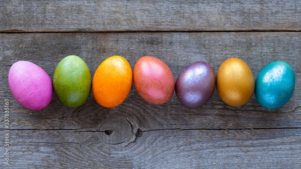 Beautiful multi-colored Easter eggs lie on a old wooden background, Easter holiday, copy space Beautiful multi-colored Easter eggs lie on a old wooden background, Easter holiday, copy space