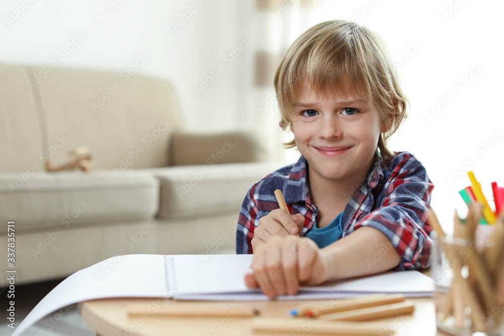 Little boy drawing at table indoors. Creative hobby Little boy drawing at table indoors. Creative hobby
