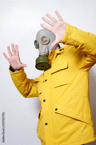 a man in a gas mask to resist the virus. raising his hands as a stop signal