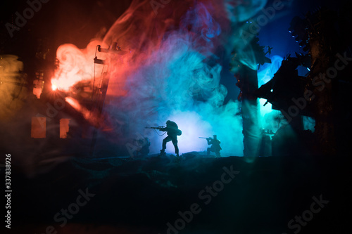 Army sniper with large caliber rifle standing in the fire and smoke. Backlit silhouette, toned image © zef art