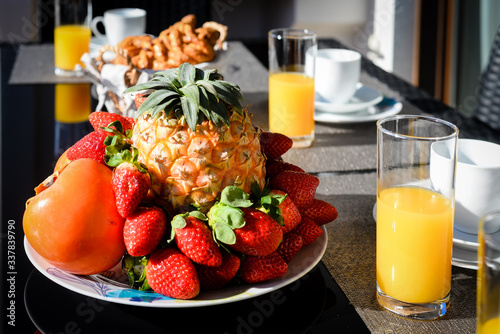 Fresh orange juice in glasses with fruit plate on a table