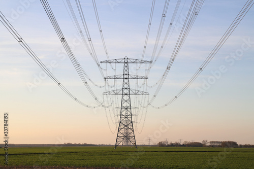 Row electricity pylon power tower landscape at sunset
