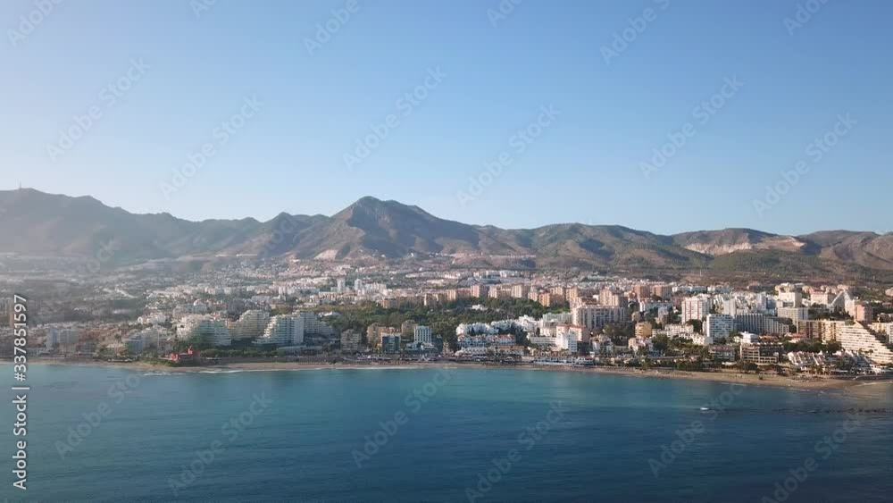 Aerial View of Benalmadena, Costa del Sol, Malaga, Spain. Panoramic view over the city and mountains in the background at the beginning of sunset, with soft warm light over the buildings Aerial View of Benalmadena, Costa del Sol, Malaga, Spain. Panoramic view over the city and mountains in the background at the beginning of sunset, with soft warm light over the buildings