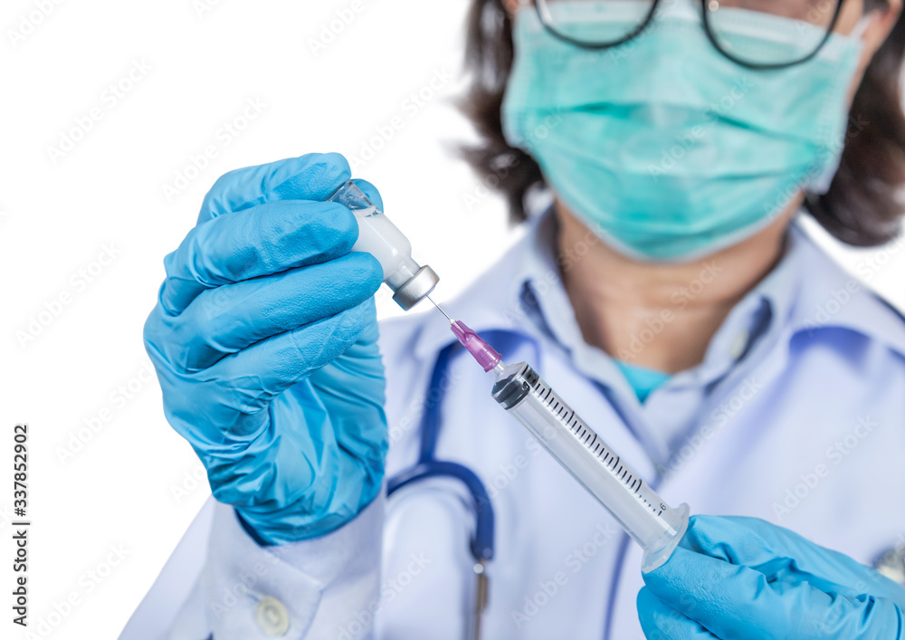 Close up syringe vaccine in hand physician while wearing surgical hygienic face mask for protection outbreak spreading coronavirus Close up syringe vaccine in hand physician while wearing surgical hygienic face mask for protection outbreak spreading coronavirus