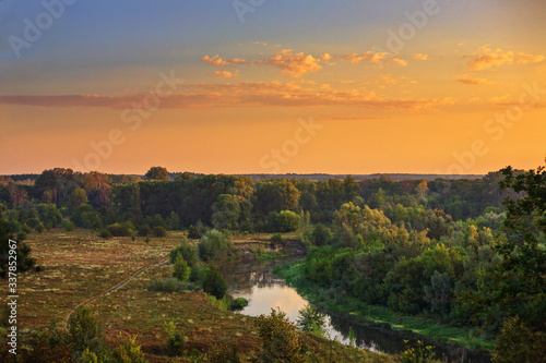 beautiful landscape dawn with clouds overlooking a forest field and a river