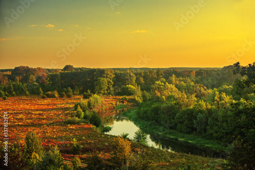 beautiful landscape dawn with clouds overlooking a forest field and a river