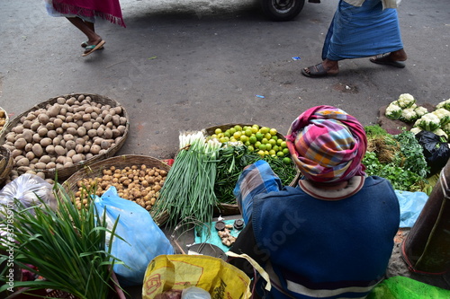 インドのコルカタ　市場の路上で野菜を販売するインド人男性　床に並べられた新鮮な野菜