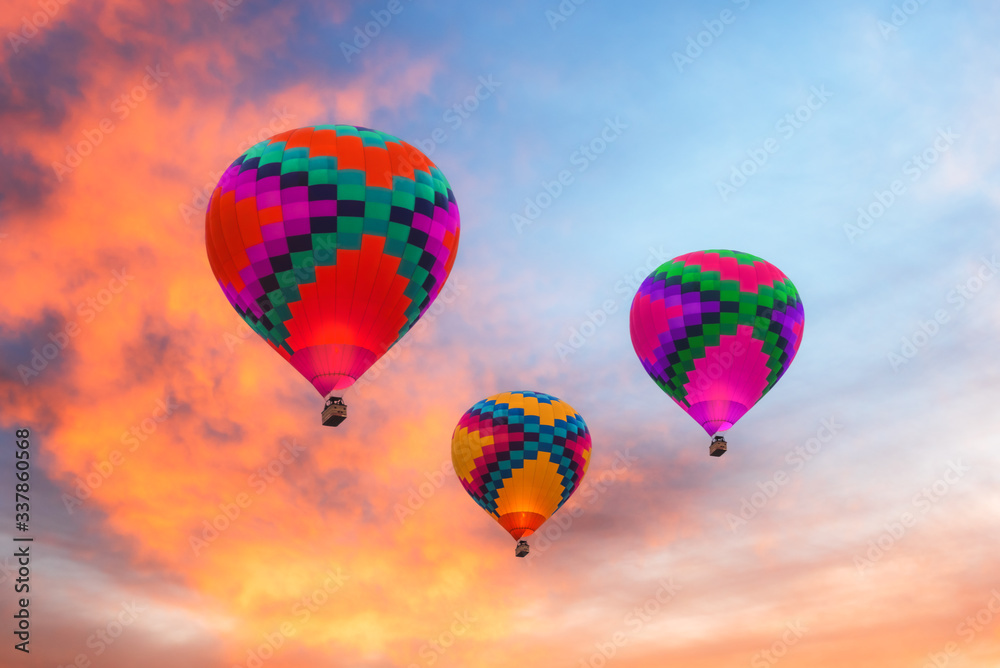 Fototapeta premium Three colorful hot air balloons against a sunset sky in Arizona.