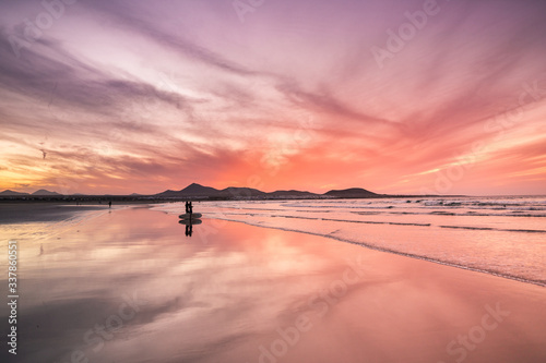 sunset in famara beach lanzarote with surfer photo