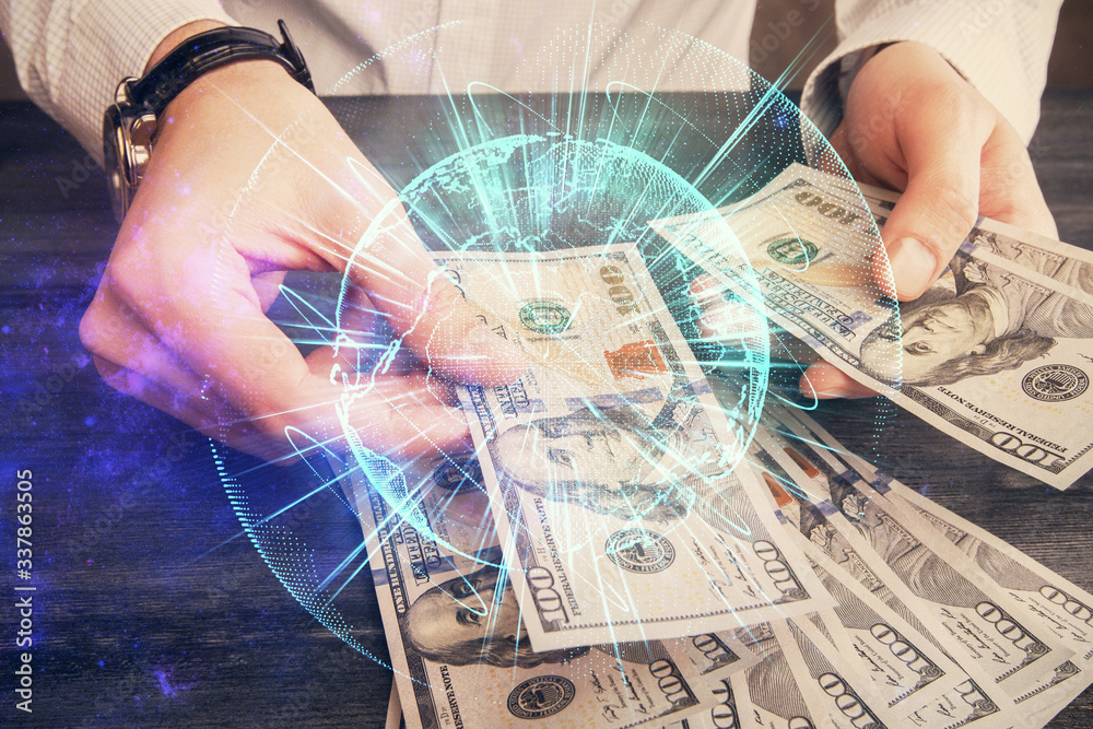 Multi exposure of financial theme drawing hologram and USA dollars bills and man hands. Business concept. Multi exposure of financial theme drawing hologram and USA dollars bills and man hands. Business concept.