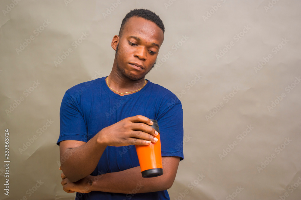 young handsome african man feeling happy as he holds a coffee cup young handsome african man feeling happy as he holds a coffee cup
