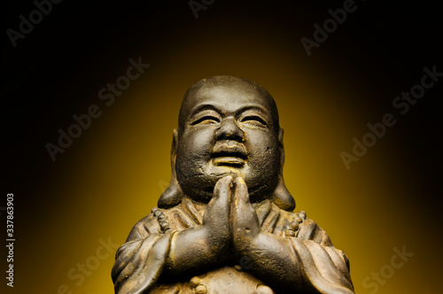 A small replica statue of The Buddha with a yellow background. Yellow representing power, royalty, and prosperity. It also represents summer