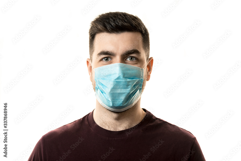 Theme of coronavirus and safety. A young man in a blue mask from a virus. Horizontal frame Theme of coronavirus and safety. A young man in a blue mask from a virus. Horizontal frame
