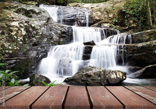 Empty brown wooden shelf floor with waterfall in nature landscape.  for montage of your product
