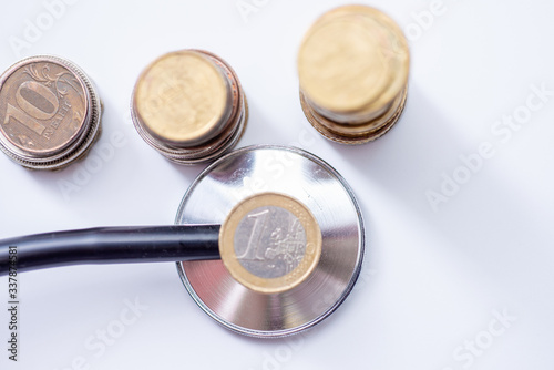 Stethoscope With Stacked Coin on white background, checkup Covid-19
