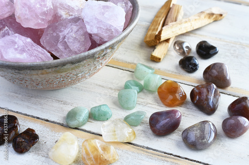 A top view image of rose quartz and various energy healing crystals on a white wooden table.  photo