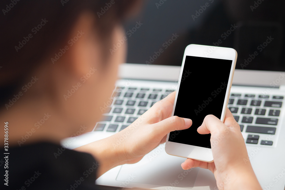 Mockup young businesswoman using smart mobile phone and laptop computer with screen blank on desk, asian woman use device internet for working, business and education concept, back view. Mockup young businesswoman using smart mobile phone and laptop computer with screen blank on desk, asian woman use device internet for working, business and education concept, back view.