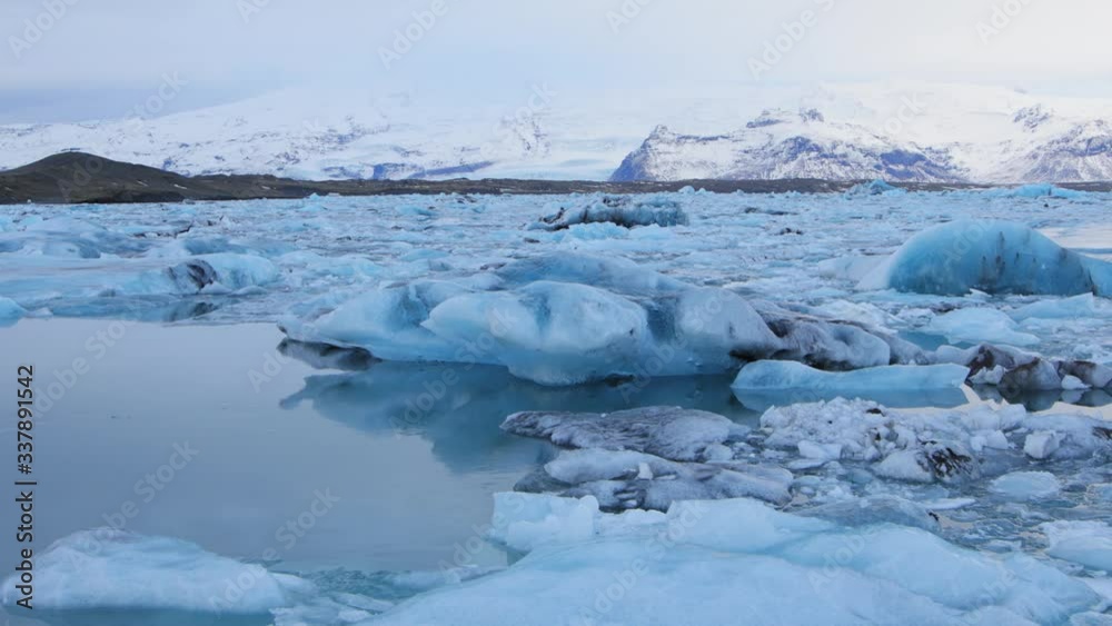 A beautiful, bluish white iceberg floating in a lake in Iceland - wide shot A beautiful, bluish white iceberg floating in a lake in Iceland - wide shot