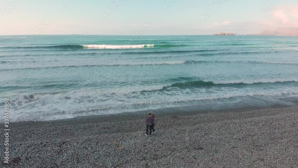 Aerial drone shot of a couple kissing and hugging at a pebble beach in Ireland Wild Atlantic Way Aerial drone shot of a couple kissing and hugging at a pebble beach in Ireland Wild Atlantic Way