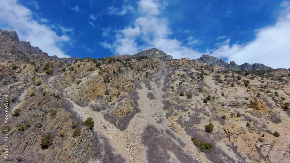 Looking up at a rugged mountain peak and flying close to it while tilting up Looking up at a rugged mountain peak and flying close to it while tilting up