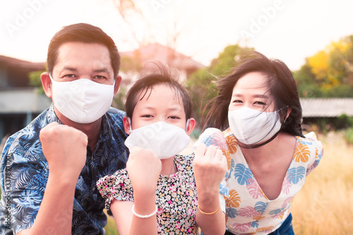 Power of family with father mother and daughter wearing medical face mask for protect 2019 - nCov , covid 19 or corona virus.Stay at home Concept
