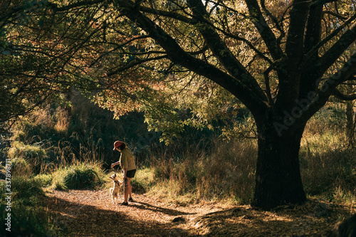 Young attractive walking with a dog in the park Oamaru, New Zealand.