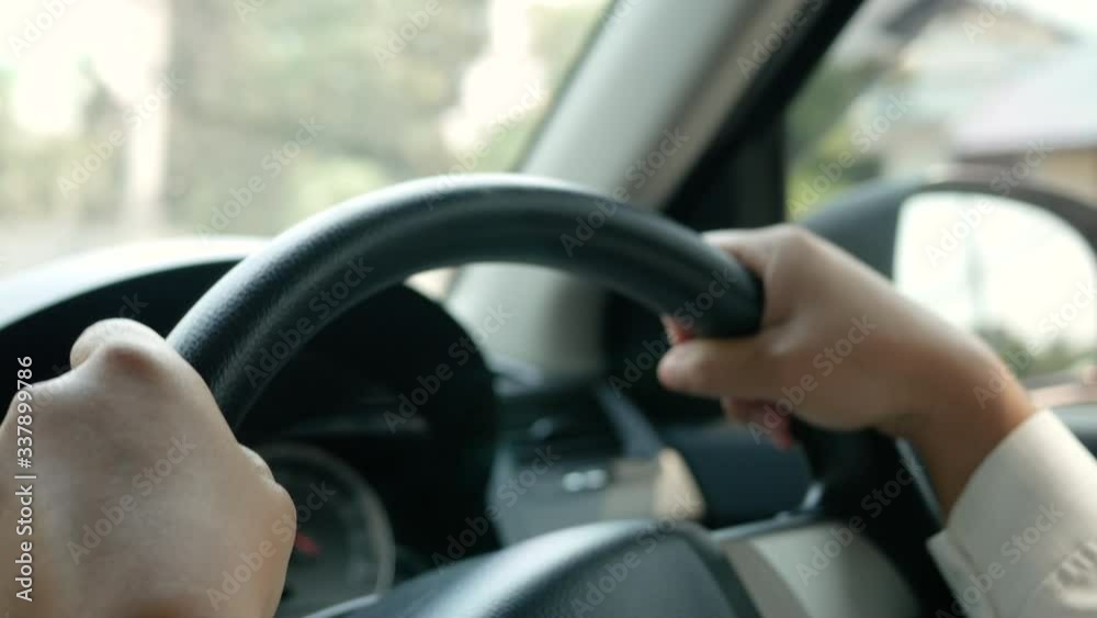 Young woman driving a car, hand put on the black steering wheel and looking forward drive with caution. Young woman driving a car, hand put on the black steering wheel and looking forward drive with caution.