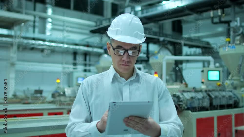 Asian, chinese Korean professional male engineer man business people in hard hat working on engineering industrial manufacturing facility using tablet indoors, worker architect inspection, slow-mo 4 K Asian, chinese Korean professional male engineer man business people in hard hat working on engineering industrial manufacturing facility using tablet indoors, worker architect inspection, slow-mo 4 K