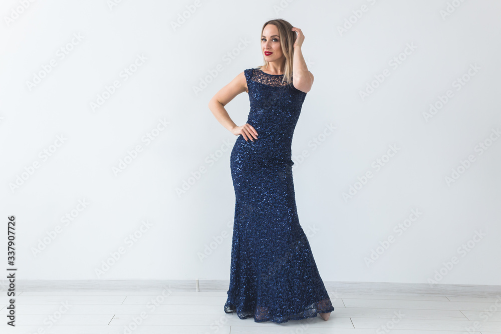 Fashionable young blonde woman in beautiful elegant dress posing at white studio. Copyspace Fashionable young blonde woman in beautiful elegant dress posing at white studio. Copyspace
