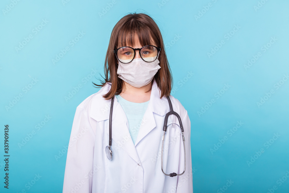 Virus, pandemic, quarantine and outbreak concept - child dressed as a doctor standing over blue background. Virus, pandemic, quarantine and outbreak concept - child dressed as a doctor standing over blue background.
