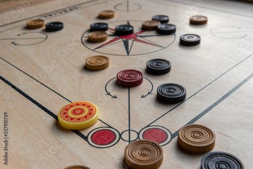 Carom board with striker and carom men. Selective focus.