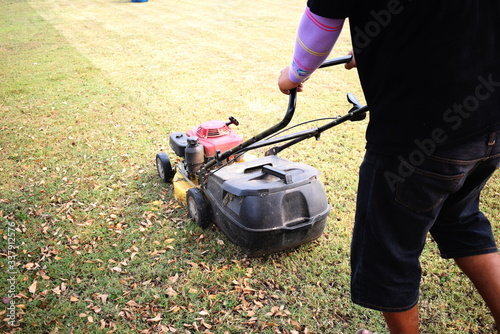 Male workers mowing fields with small motor vehicles