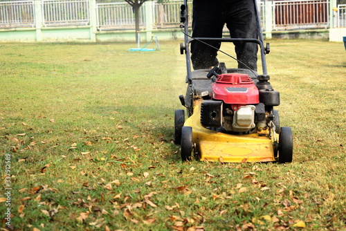 Male workers mowing fields with motor vehicles