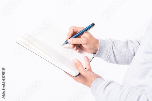 ノートにメモを書く男性