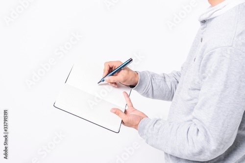 ノートにメモを書く男性