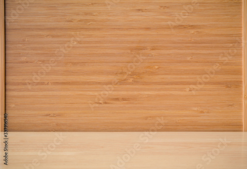 Empty wood table with bamboo background. Bamboo products that have been processed into trays for use in the kitchen. Top view of plank wood for graphic stand design product.