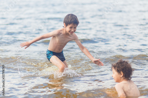 boys in blue swimming trunks having fun in the lake in summer