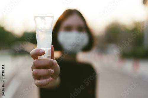 Asian people using alcohol antiseptic gel and wearing mask,prevent against infection of Covid-19 outbreak,woman washing hands with hand sanitizer to avoid contaminating with Corona virus