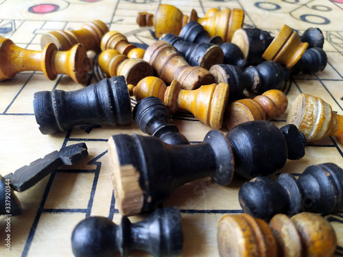 some chess pieces put on wooden carrom board