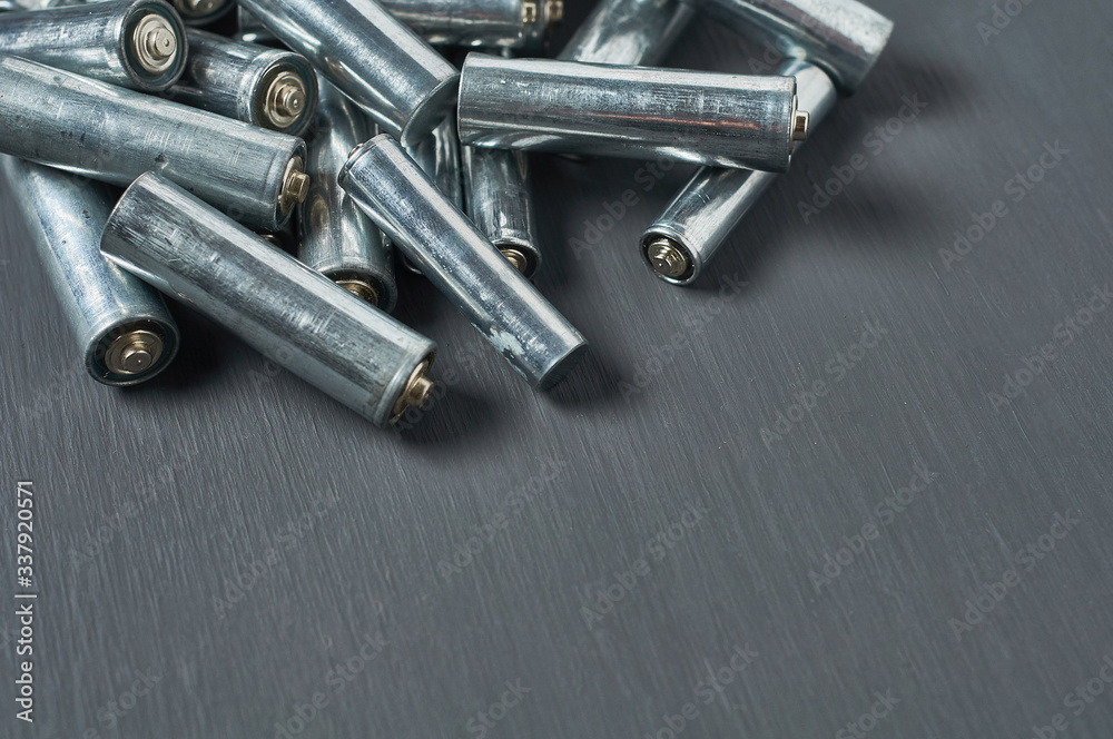 Heap of old dirty batteries aa or aaa size on dark concrete desk. Recycling concept. Save environment. Alternative energy Heap of old dirty batteries aa or aaa size on dark concrete desk. Recycling concept. Save environment. Alternative energy