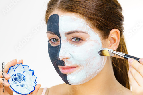 Girl black mask on half face apply white mud photo