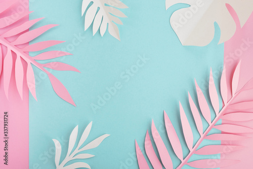 Tropical leaves and frame on bright background. Paper palm and monstera leaves. Minimal summer composition in pastel colors. Top view, flat lay, copy space