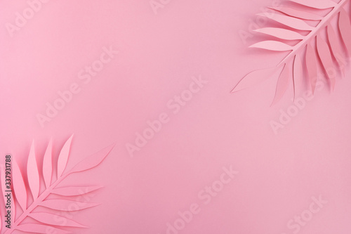 Paper palm leaves on light pink background. Minimal summer composition in pastel colors. Top view, flat lay, copy space © Elena