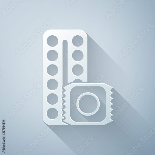 Paper cut Packaging of birth control pills and condom in package safe sex icon isolated on grey background. Contraceptive pill. Paper art style. Vector Illustration